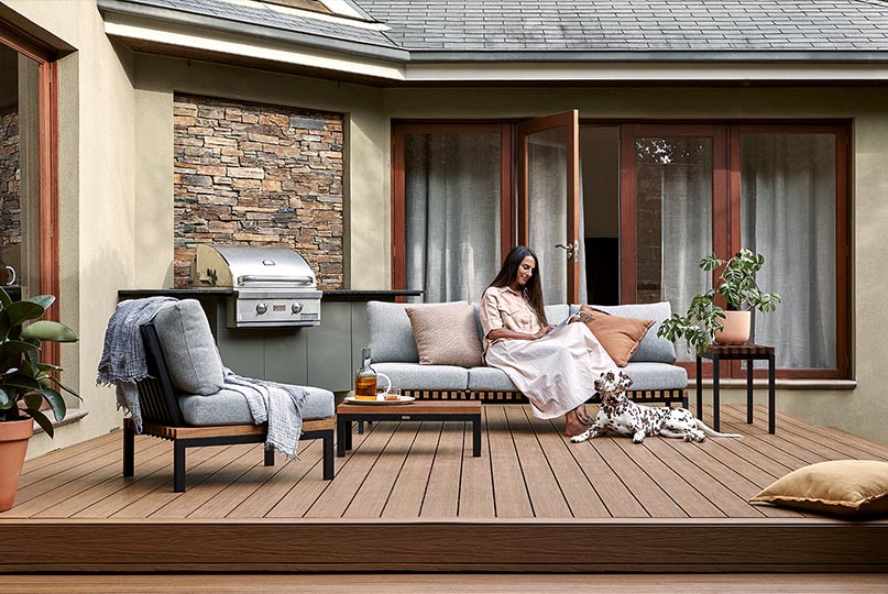 A woman sitting on a wooden deck.