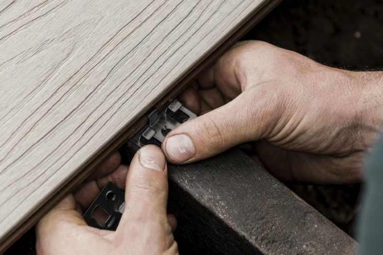 A person is working on a wooden plank.