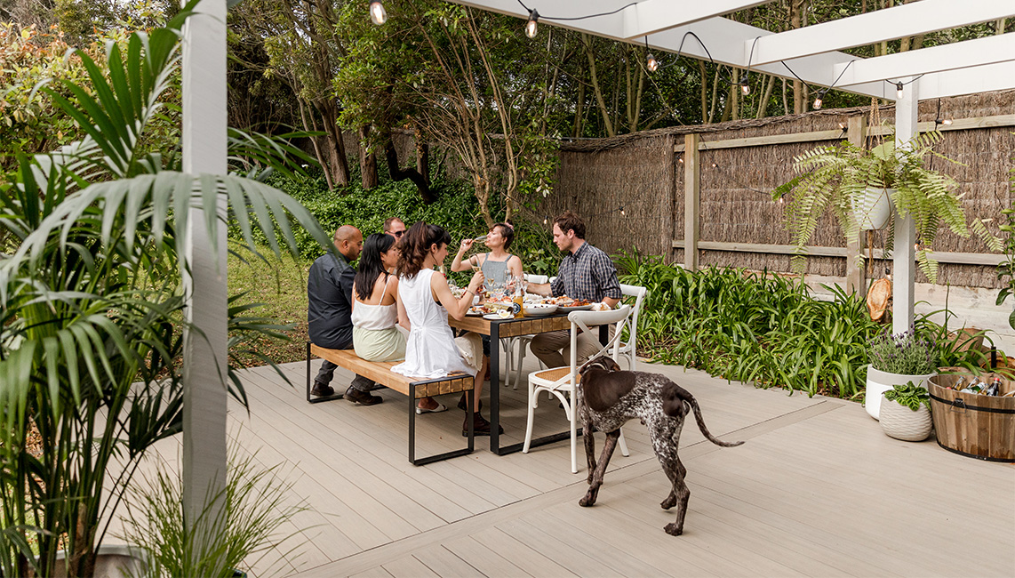 A group of people sitting around a table with a dog.
