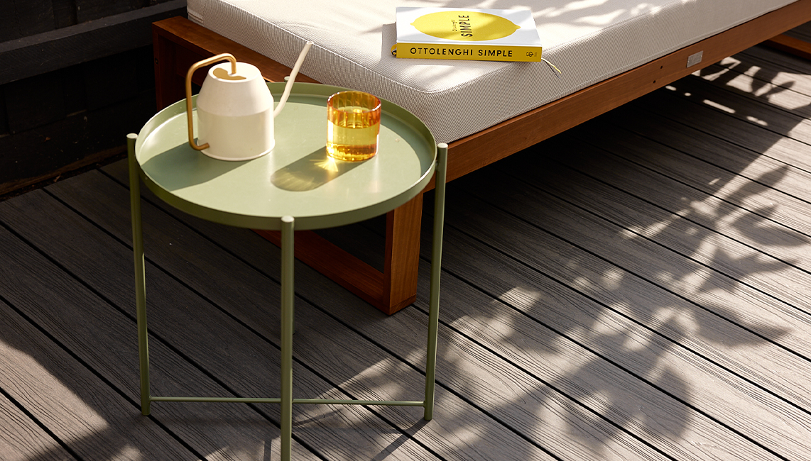 A wooden deck with a bench and a table.
