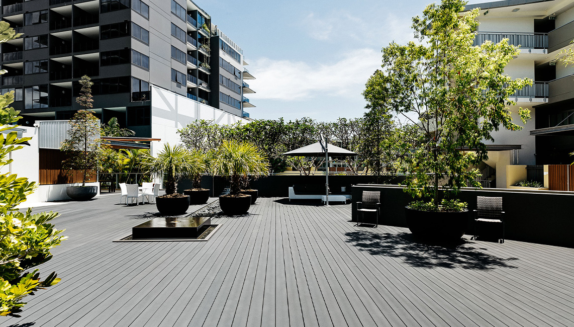 A wooden deck with plants and trees.